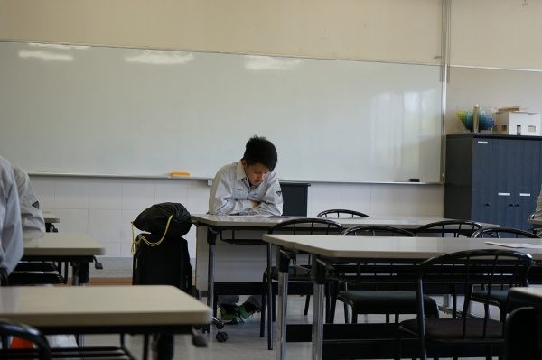 入校式で机に向かい座っている緊張した様子の石田君