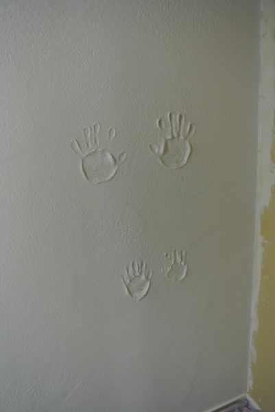 漆喰の壁に兄弟2人の手形