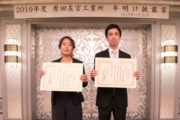 左官組合の見習工修了証書を持った男性と女性