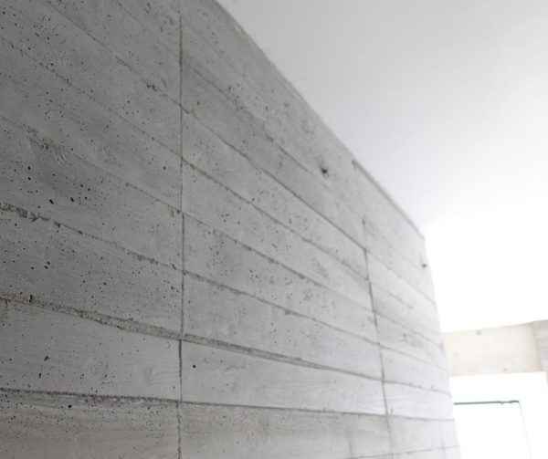 うづくり木目モルタルのエントランス壁、板目は目地を通した芋張りの仕上げ、壁と天井の境