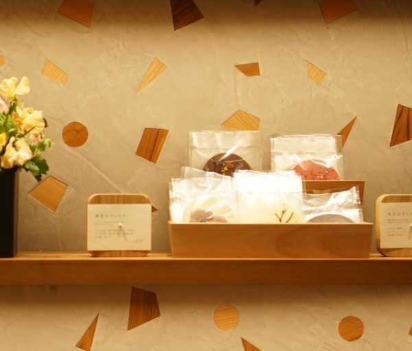 木片+モラート仕上げの壁と商品棚、棚には商品や花が並んでいる、正面アングル画像