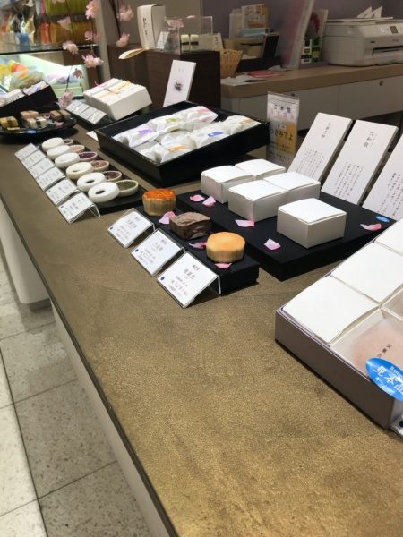 金色のオルトレマテリアで施工されたディスプレイ用カウンターテーブル、巌邑堂日本橋高島屋店、商品の和菓子が様々な種類で沢山ある