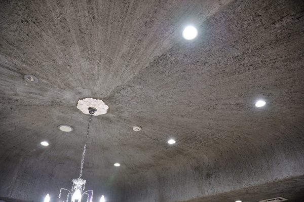 モルタル特殊仕上げの天井、放射線状に刷毛目が入っている。シャンデリアや他の照明がある。お蕎麦屋さん「小松庵　総本家」