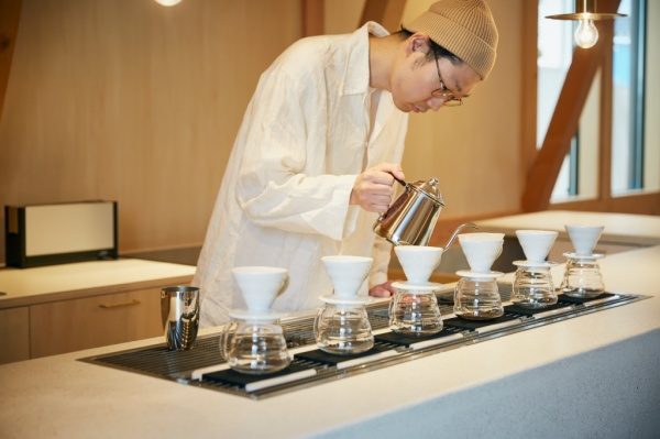 セメント研ぎ出しのカフェカウンター。店員さんがコーヒーを淹れている