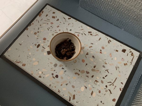 ビールストーン神農茶の茶葉入りサンプル板。板の上に神農茶の茶葉入りお茶碗がある