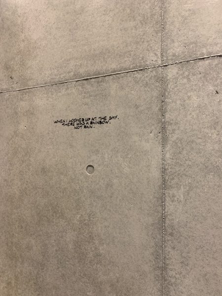 原田左官コンクリート打ち放し風仕上げ壁。カフェの壁面に施工、壁面にはアートやメッセージが書かれている