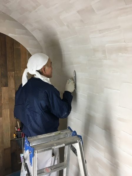 イタリアンレストランに施工された原田左官オリジナルのジョリパット乱流2色仕上げの壁。開発者の岩本裕二さん施工中の様子