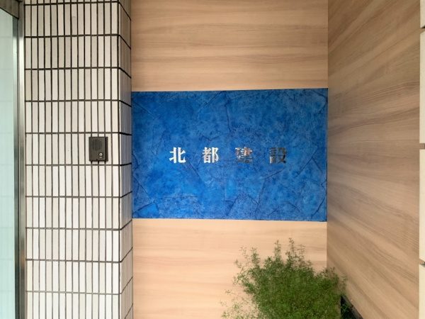 北都建設様エントランス施工完成。樹脂系左官材のブルー、白２色で施工し切り文字が付いた状態