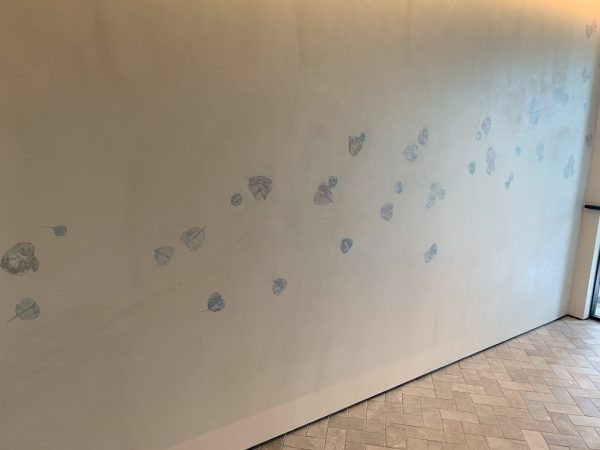 住宅展示場のオルトレマテリア葉っぱ入り仕上げの壁。仕上がり完成の状態。オルトレマテリアを塗る人と葉っぱを貼り付けて伏せ込む人を分けて施工している。原田左官施工