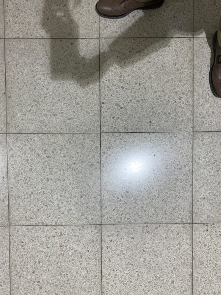 公共施設のテラゾタイル床。従来型のテラゾで白いタイルの目地が汚れくすんでしまっている