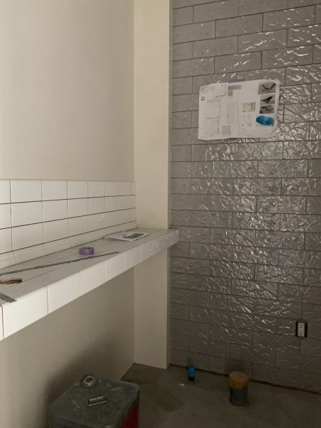 トイレ壁面の紙をクシャクシャにした模様のタイル。施工中の様子
