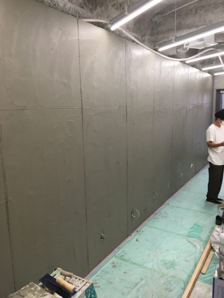 石膏ボード下地に造形モルタルを施工しコンクリート調に成型中の渋谷美容室の壁
