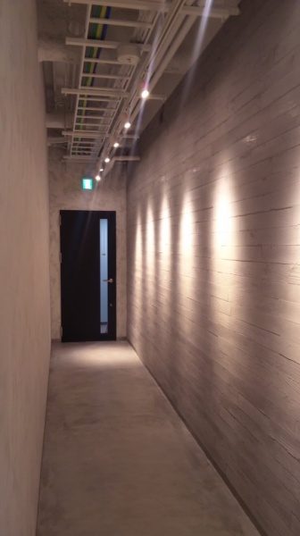 うづくり木目モルタル壁のある廊下。板幅は90ｍｍで色はライトグレー