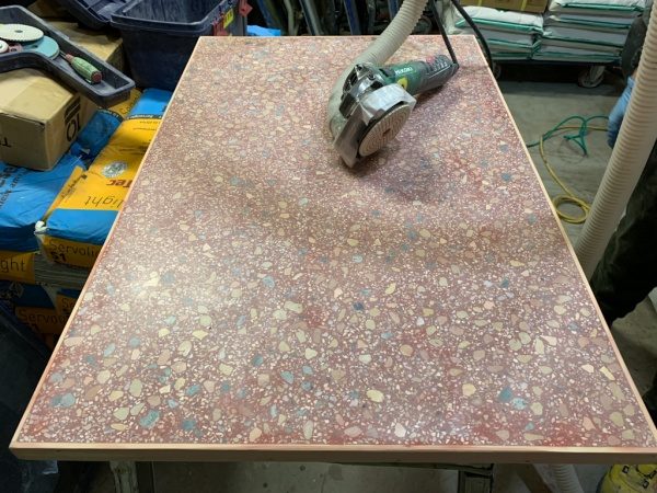ビールストーンの赤いマルチカラーのテーブル天板。研ぎ出し中の状態