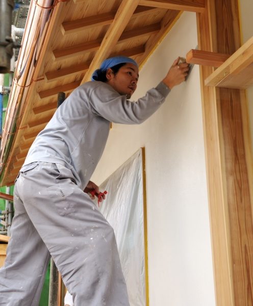 鏝で壁を塗っている左官職人さん