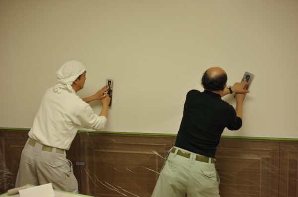 壁を塗る2人の左官職人