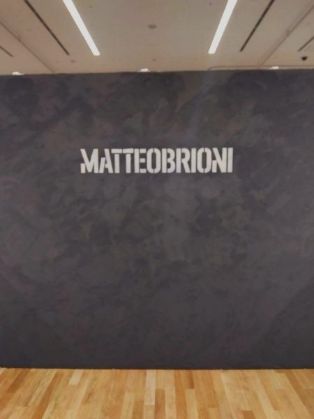 マッテオブリオーニのロゴ入り壁。壁面：ペペネロ色、ロゴ：ラテ色