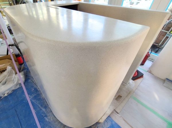 ビールストーン施工の白くて角の丸いカウンター什器