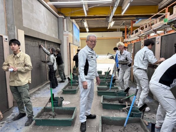 塗り壁トレーニングをする見習い工の新人さん達と指導する講師の先生