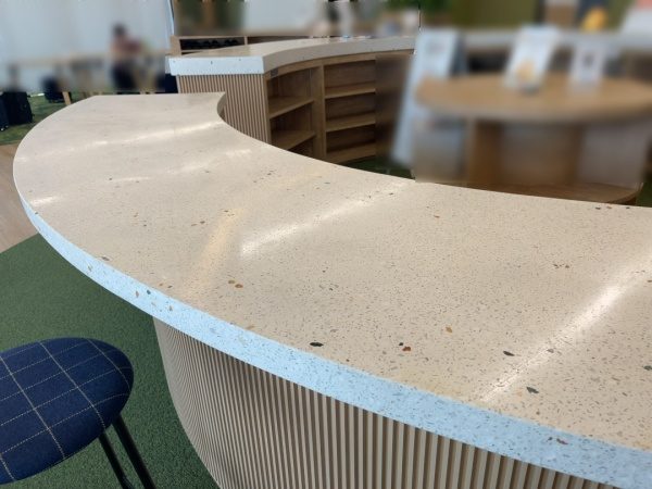 白いビールストーンで施工した円形の受付カウンター天板