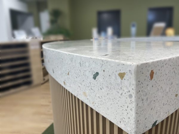白いビールストーンで施工した円形の受付カウンター天板