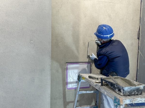 コンクリート打ち放し風仕上げ施工の塗り付け完了直後の様子。左側：本物のコンクリート打ち放し壁