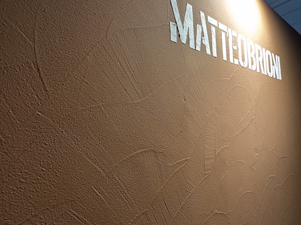 マッテオ・ブリオーニで施工した展示会の壁。色はCAMMEO(カメオ)で文字部分は白い土のLATTE(ラテ)
