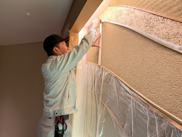 施工途中の縦縞模様のリシン掻き落とし壁
