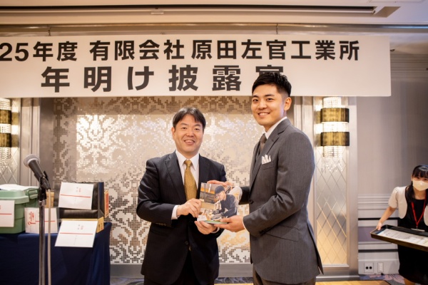 代表からフォトブックを渡される大野さん。原田左官工業所の2025年度年明け披露会