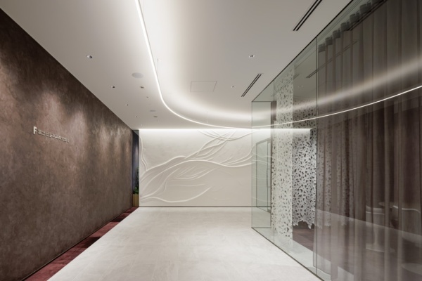 オフィスエントランスホールの壁に施工した原田左官オリジナル漆喰「フルーフレ」の壁。桜の木をイメージした模様のアートウォール