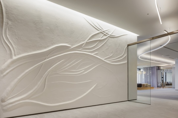 オフィスエントランスホールの壁に施工した原田左官オリジナル漆喰「フルーフレ」の壁。桜の木をイメージした模様のアートウォール