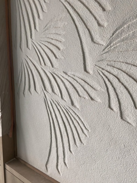 ホテル客室の壁面に施工した特注の掻き落とし仕上げ壁