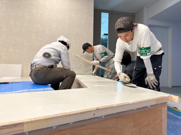 オフィスのベンチを施工する左官職人