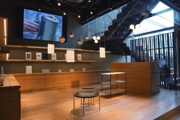 More than Covering MINAMI AOYAMAの展示場に展示された黒いモールテックスで施工したテーブルとスツールがある風景