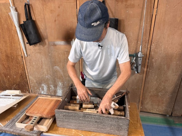 中島さんが道具箱に入っている鏝を触っている